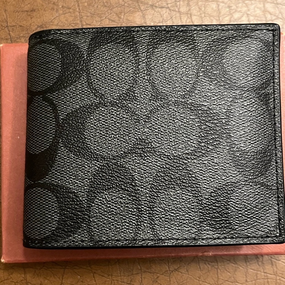 Coach grey and black wallet with coach logos insignias. Very good condition.